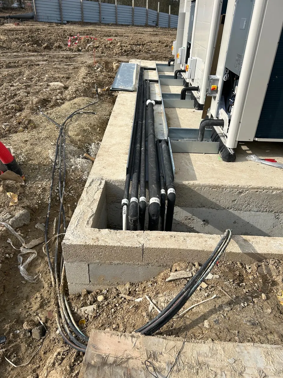 Tranchée de tuyauterie frigorifique sur un chantier